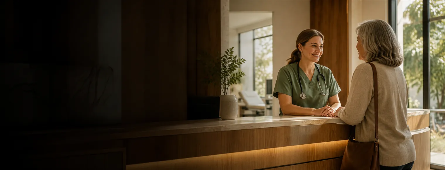 A nurse greeting a patient at a clinic reception counter